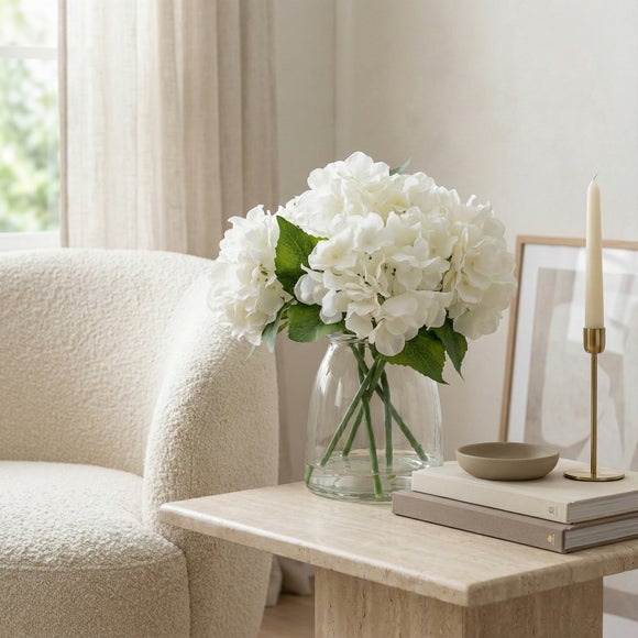 Photo of artificial white hydrangeas in glass vase